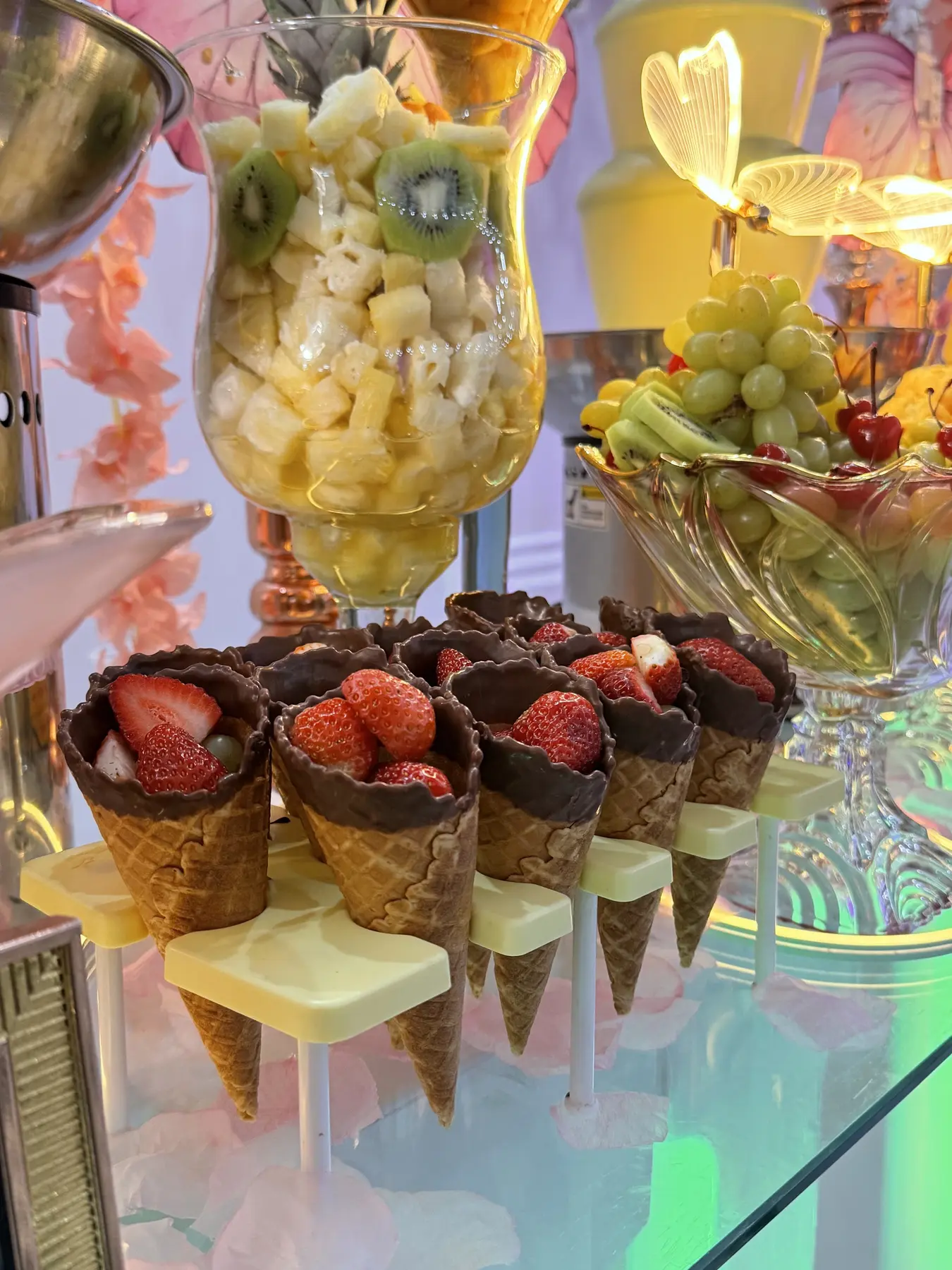 Cones com frutas e chocolate em estação de sobremesas